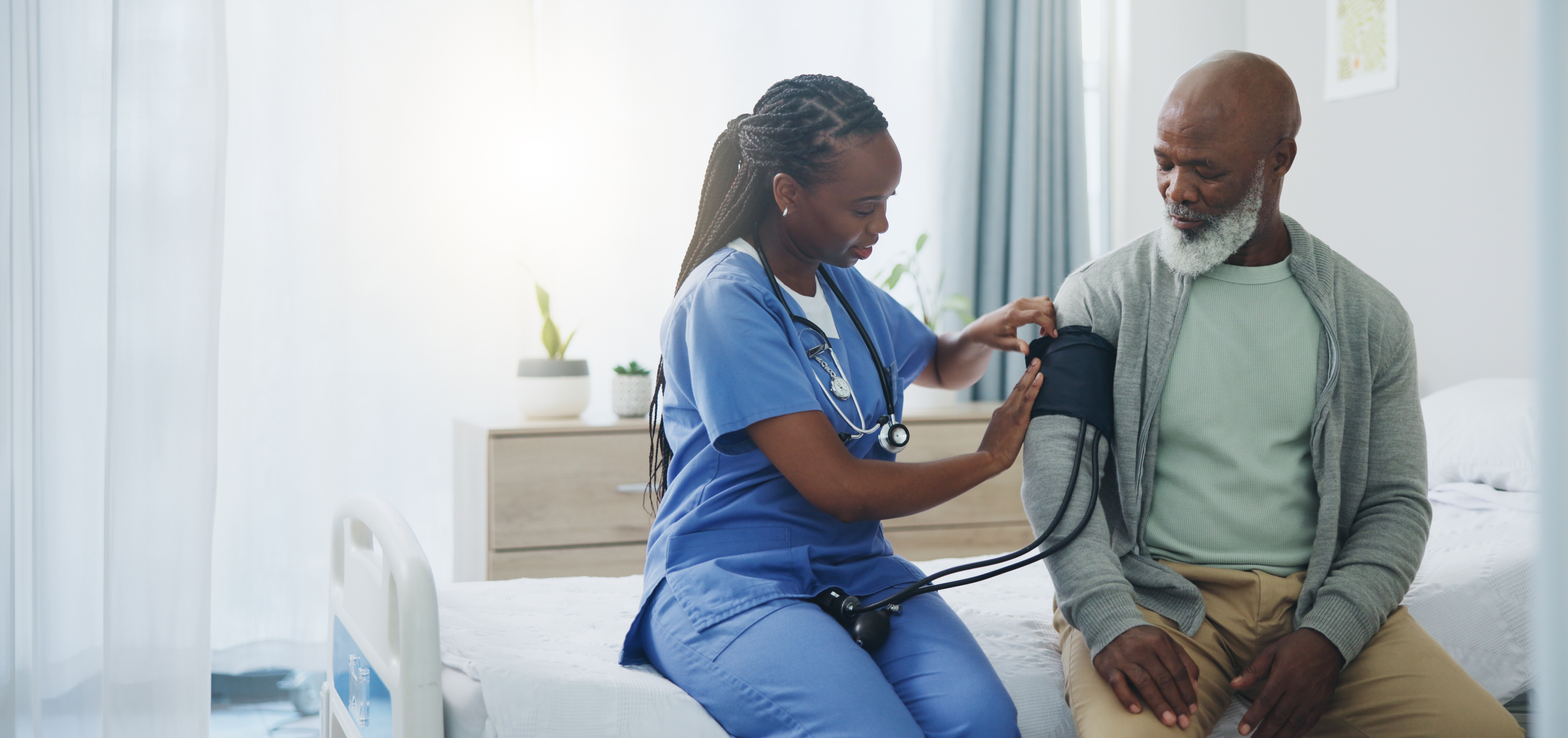 A woman taking a man's blood pressure