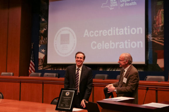 Image of the commissioner with a plaque